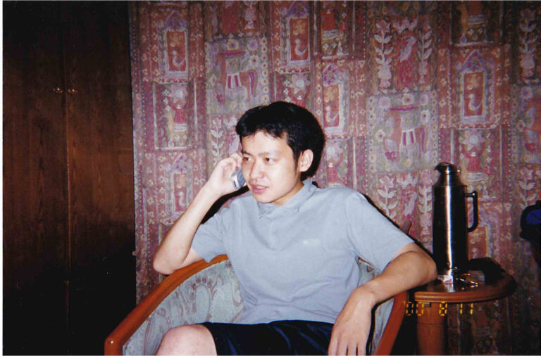 【写真5】まだスマホもない頃。現地の携帯片手にキメてます